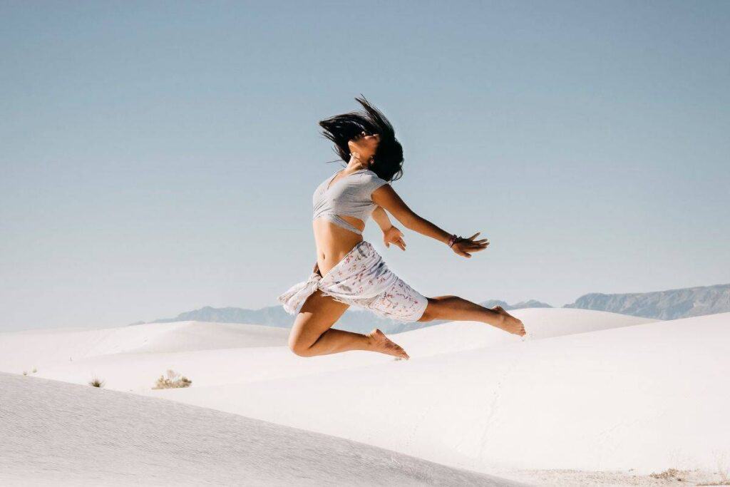 Catherine Xu jumping in white sands on a sunny day