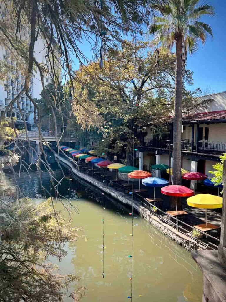 San antonio riverwalk in the daytime with colorful umbrellas