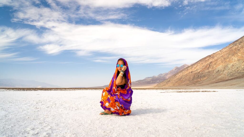 Cat Xu kneeling in the badwater salt flats, one of the best things to Do in Death Valley