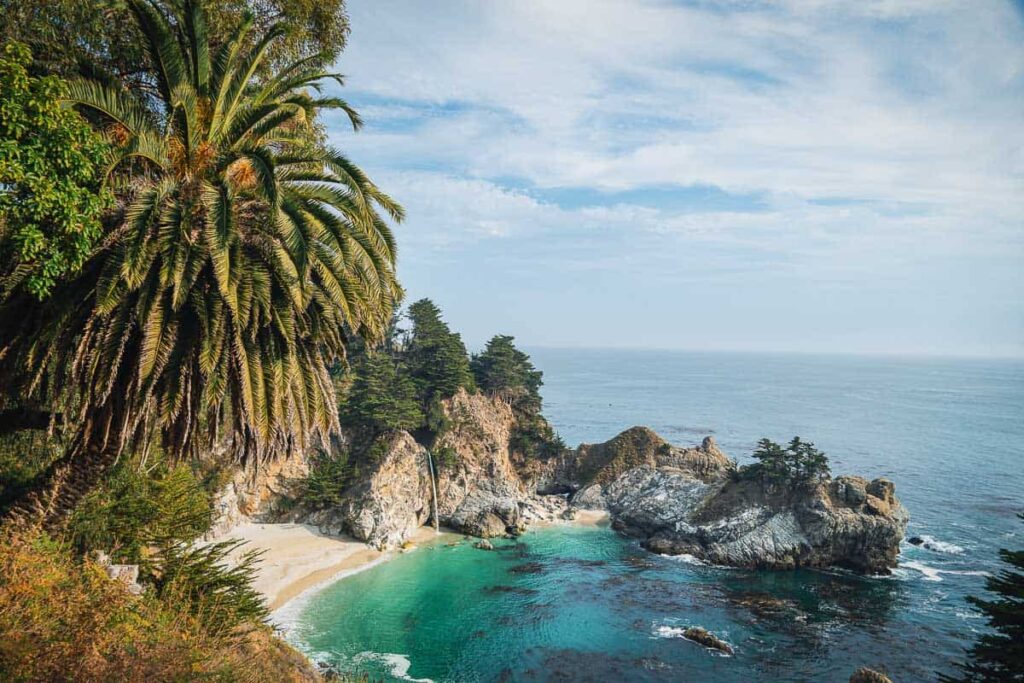 Waterfall in Big Sur and turquoise water and palm trees, one of the most beautiful waterfalls in the US