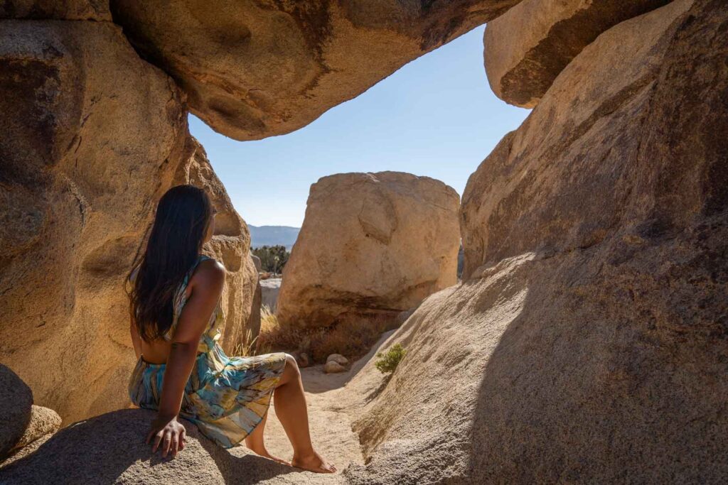 day trip nomad cat xu sitting amongst the boulders on a day trip to joshua tree