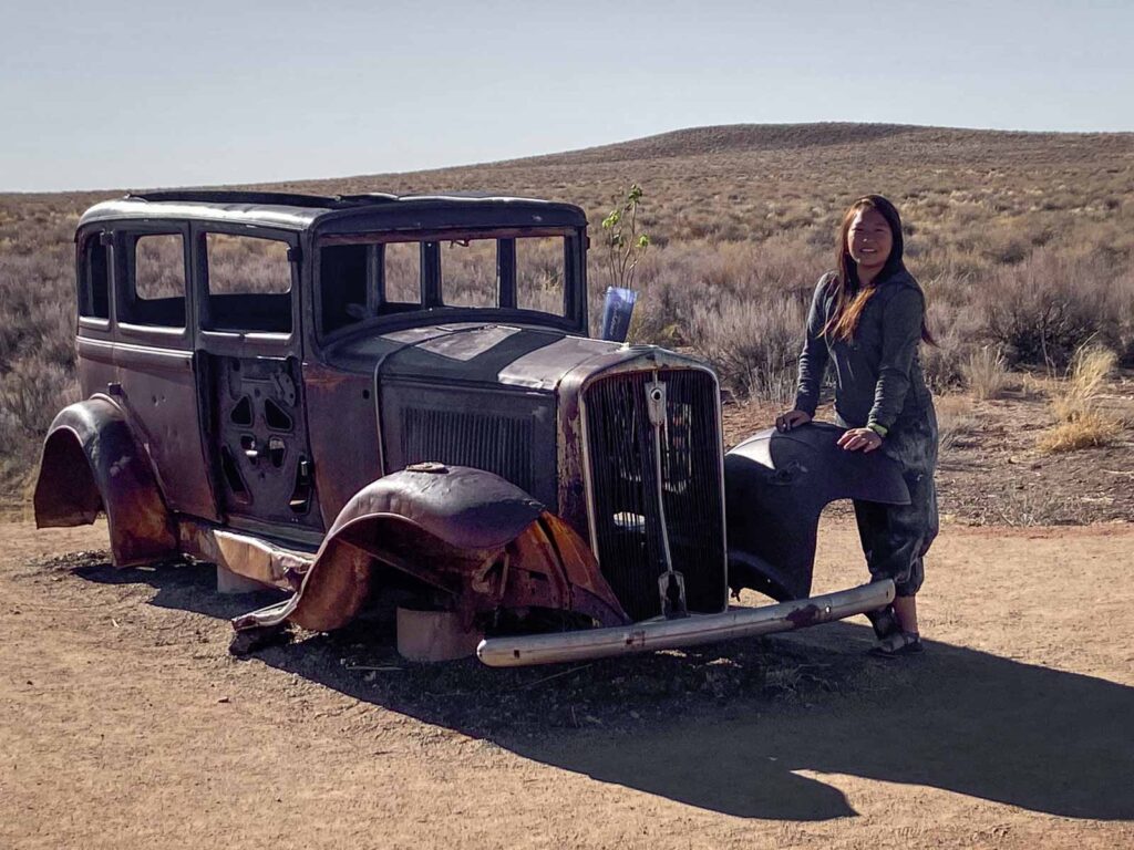 catherine xu standing in front of the old studebaker in petrified forest national park and the historic route 66