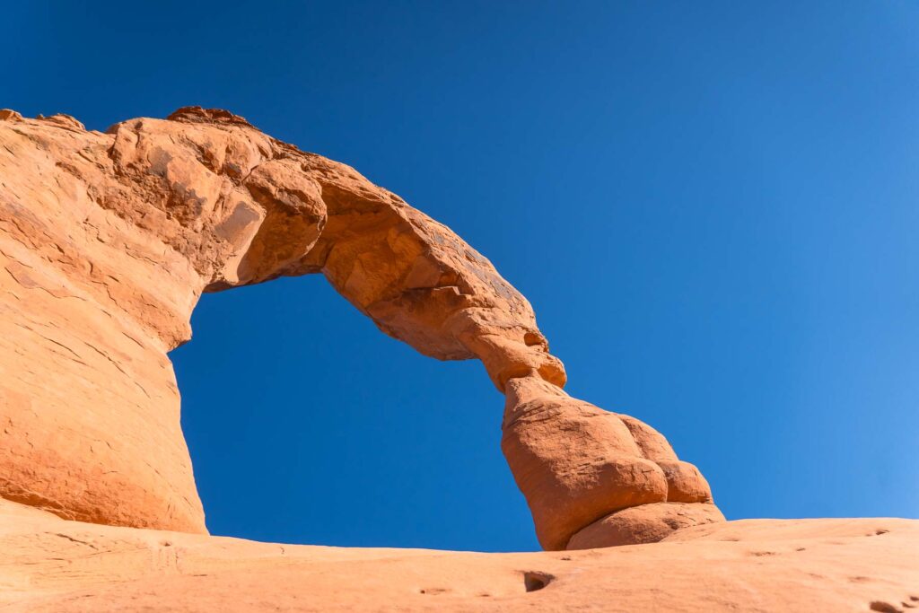 Delicate Arch standing tall against a clear blue sky at Arches National Park.