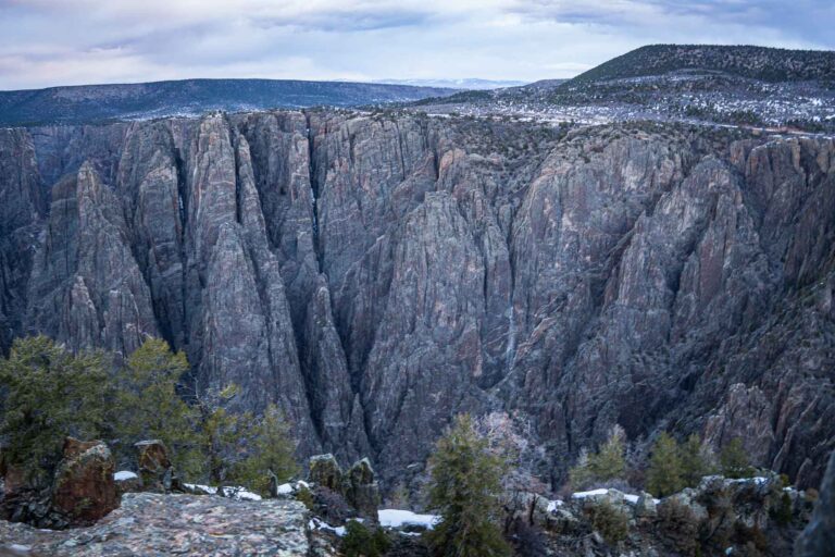 Panoramic view of the Black Canyon under a cloudy blue sky.