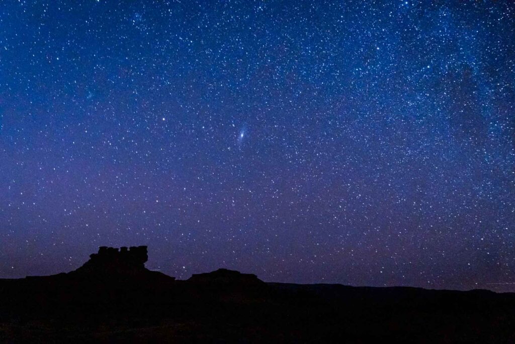 A night sky filled with countless stars above the silhouetted canyons in canyonlands national park