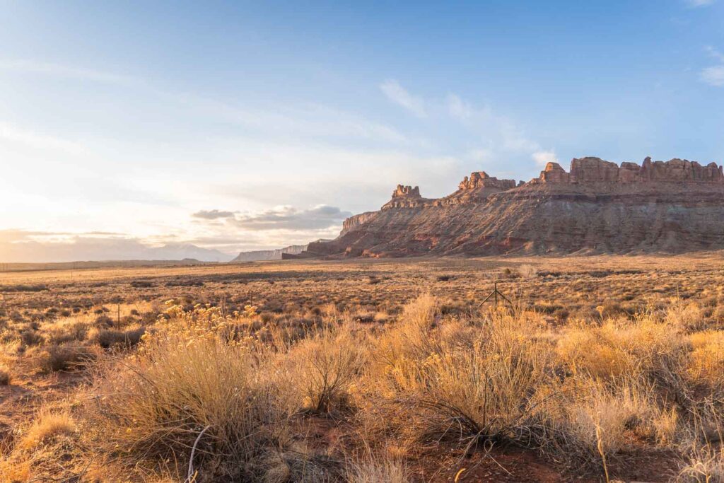 A serene sunset casting a warm glow over the buttes in canyonlands national park