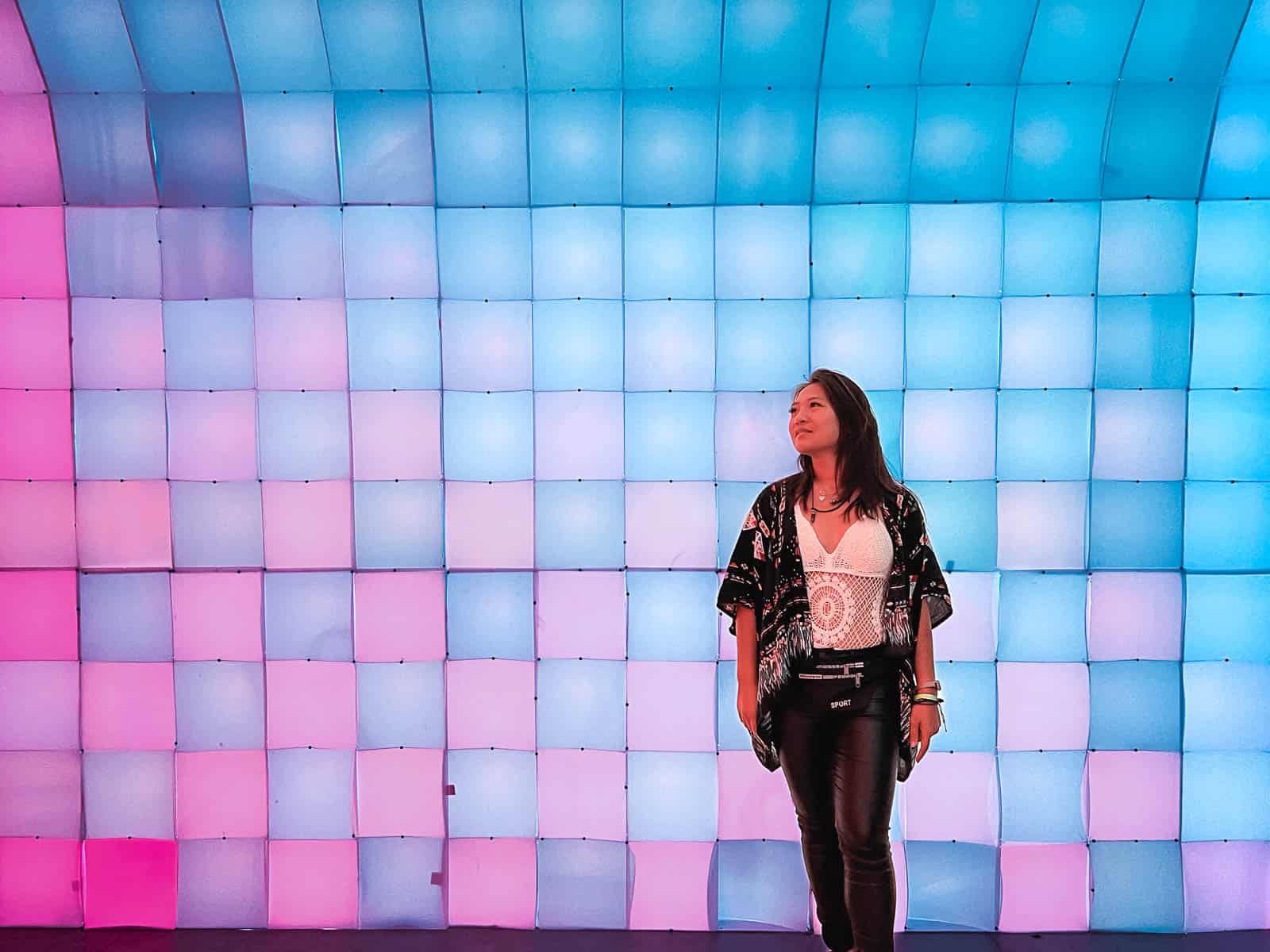 cat xu posing in front of a colorful wall