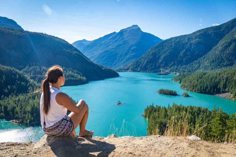 cat xu sitting on the diablo lake overlook on a sunny day with beautiful blue water