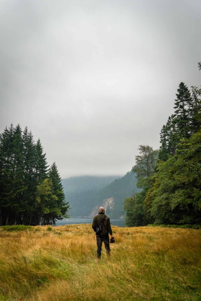 silhouette figure in a meadow by a lake in washington