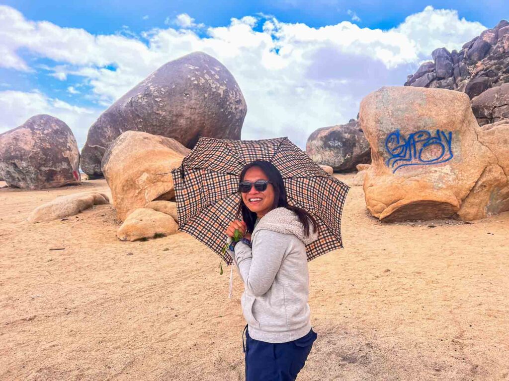 cat xu undereath an umbrealla in joshua tree while it was hailing 