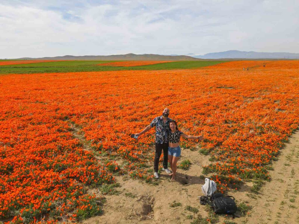 Cat Xu and Brazilian friend smiling in front of the poppy fields from a bird's eye view. It's one of the coolest day trips from Los Angeles
