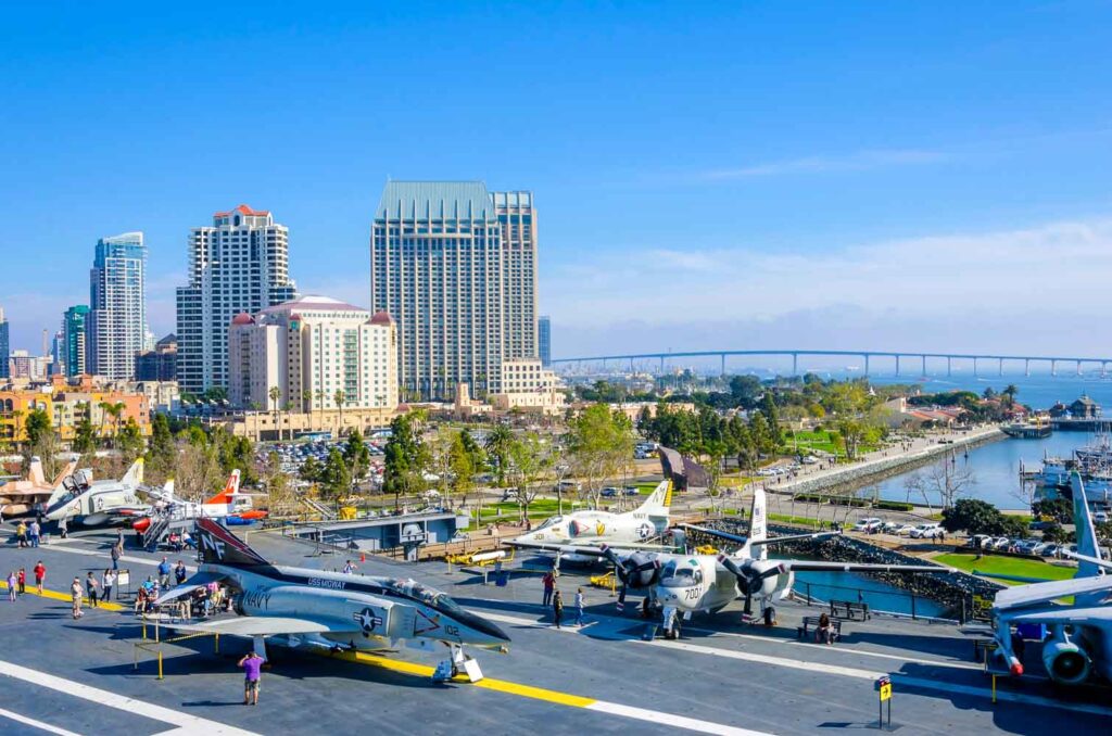The historic aircraft carrier, USS Midway Museum moored in Broadway Pier in Downtown San Diego, Southern California, United States of America and the skyline. A battleship commissioned after the World War II.