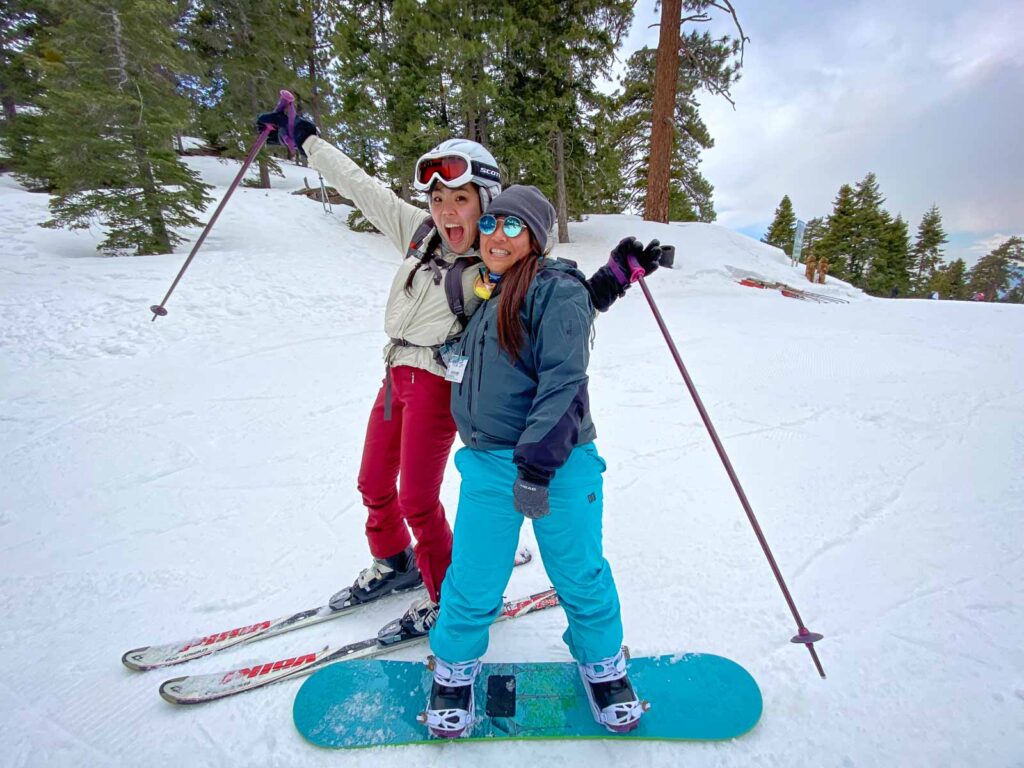 catherine xu and friend posting while skiing and snowboarding