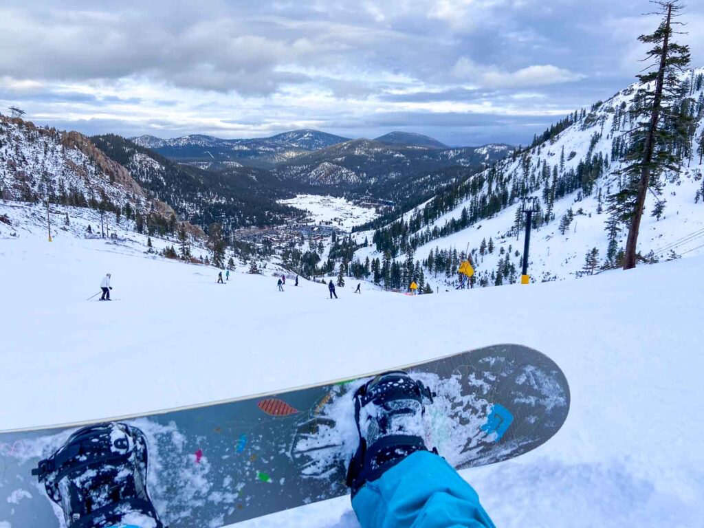 catherine xu's snowboard in front of the mountains and slopes of palisades tahoe