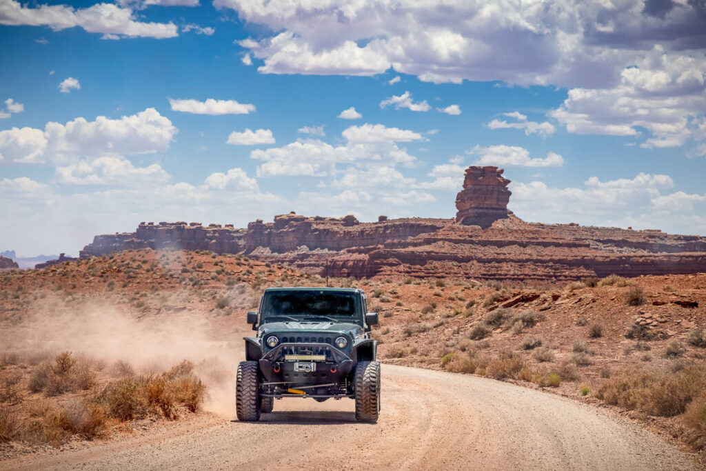 Landscape scenes in the american southwest with a jeep driving down a dirt road