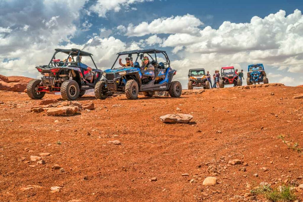 Group of ATV riders enjoys a break on a summit of the Hurrah Pass on the popular Chicken Corner trail in the Moab area.