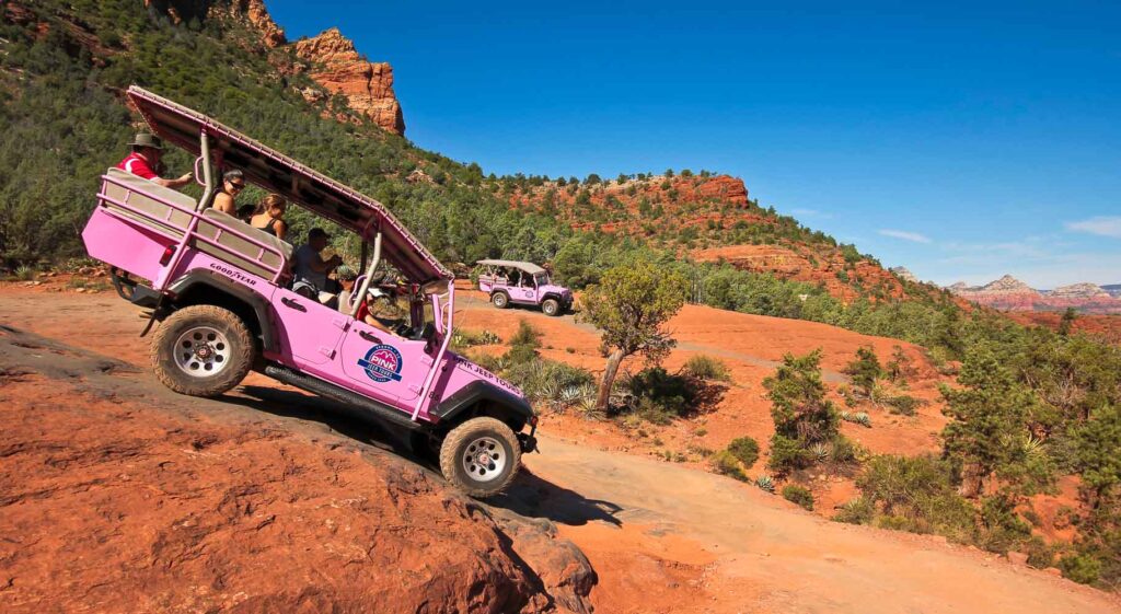 A Pink Jeep Tours vehicle loaded with tourists on the Broken Arrow Trail near Sedona, Arizona.