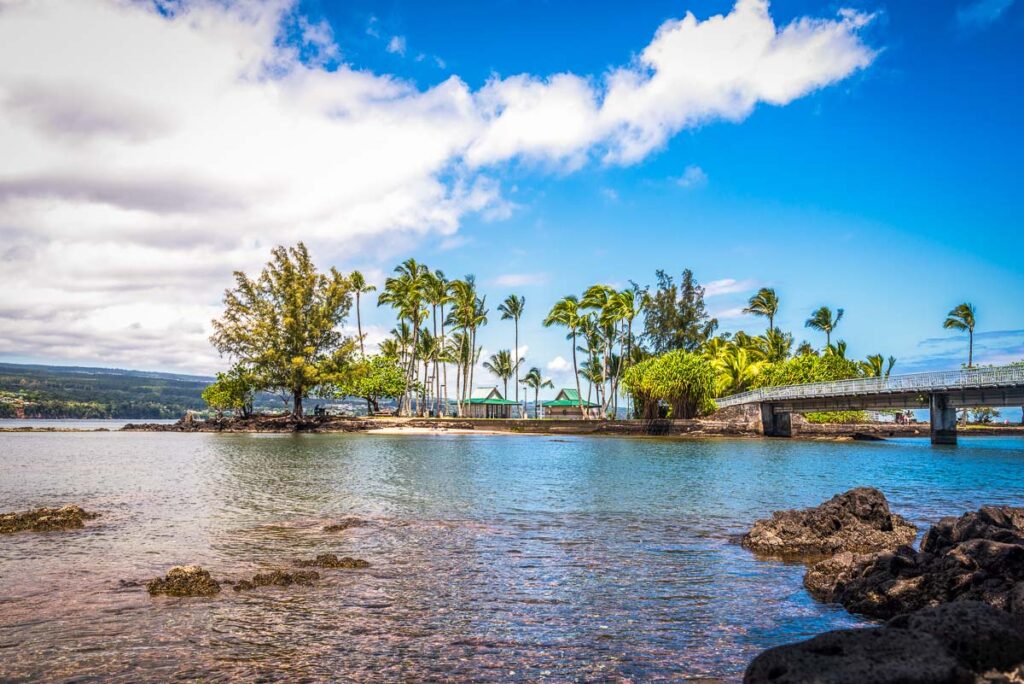 Coconut Island Hawaii depicts a calm day with gentle waves washing ashore highlighting the tropical climate and look of paradise.