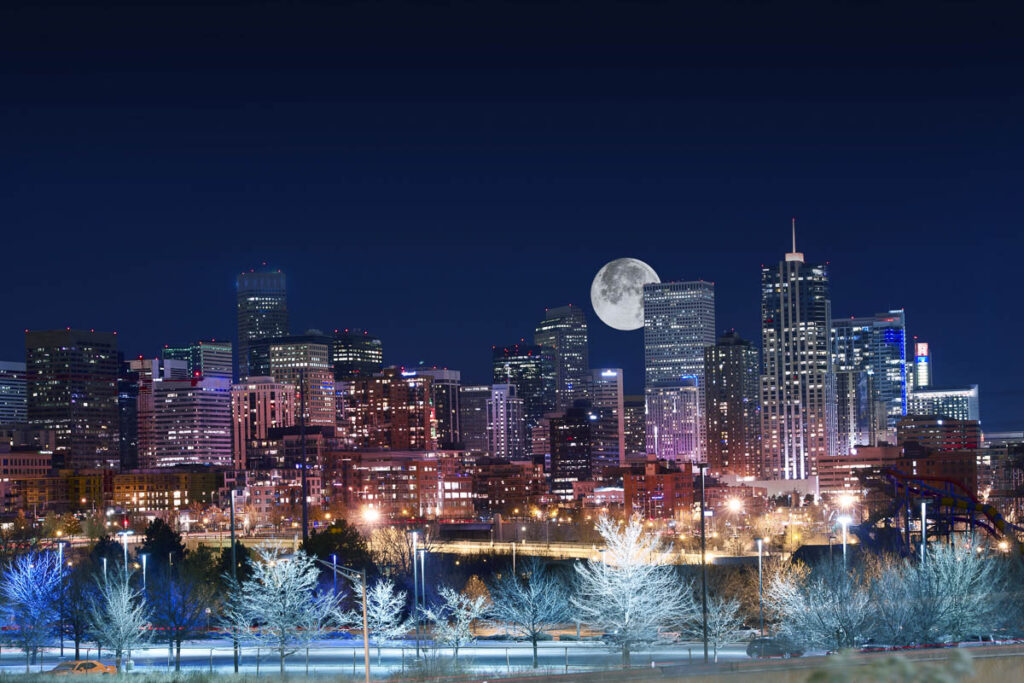 Denver Night Skyline with the full moon behind lights