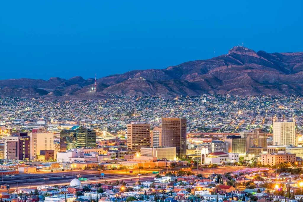 Downtown city skyline at dusk with Juarez, Mexico in the distance, one of the easiest day trips from El Paso