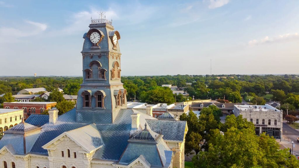 Aerial view close up the Clock Tower on top of Hood County Courthouse in Historic Granbury Square, Texas, America. Traditional landmarks surrounded by unique boutiques, restaurants, bistro