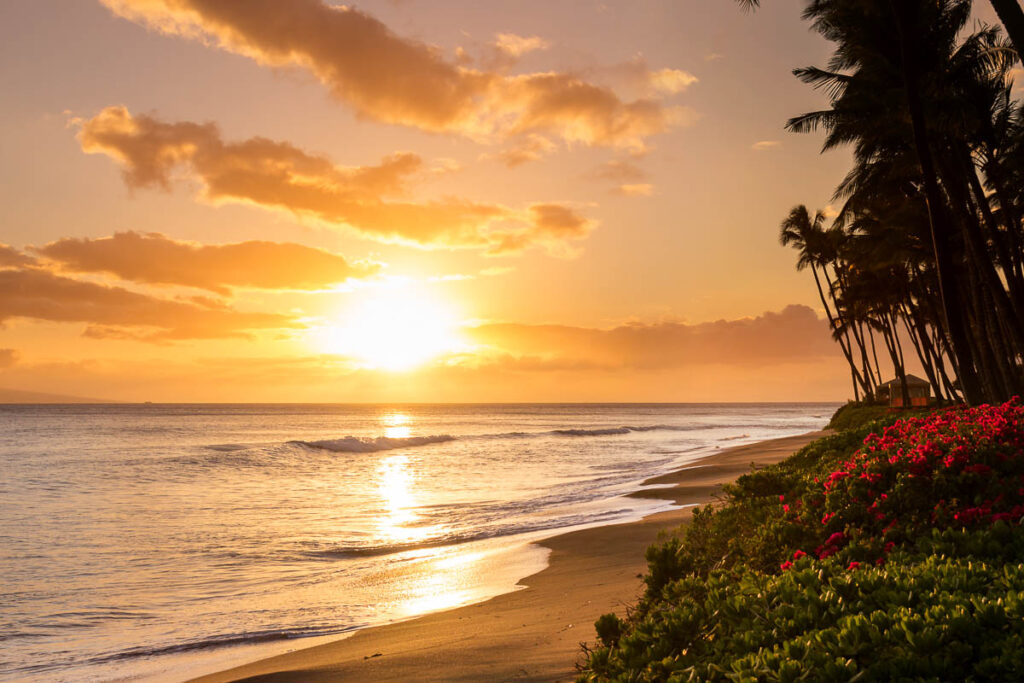 Beautiful, warm tropical sunset on the white sands of Kaanapali Beach in Maui, Hawaii. A fabulous destination for vacation and travel.