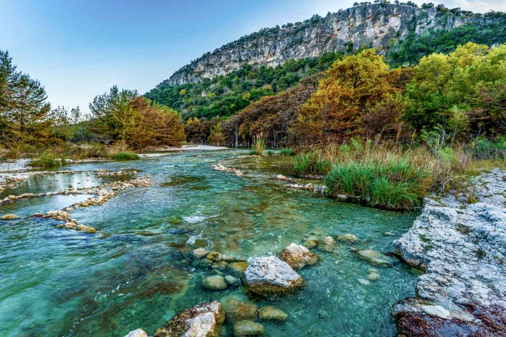 Fall Foliage on Trees Lining the Crystal Clear Frio River at Garner State Park, Texas.