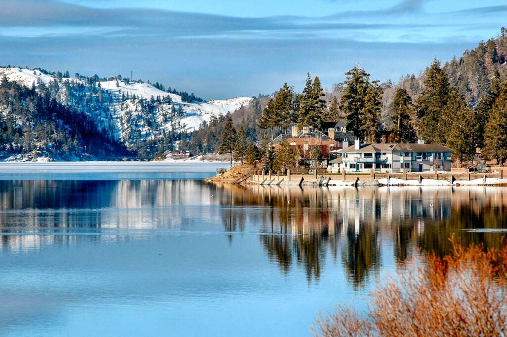 The calm waters of Big Bear Lake with a mansion in view