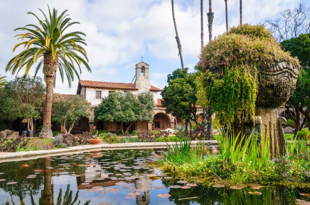 Mission San Juan Capistrano in front of a green pond