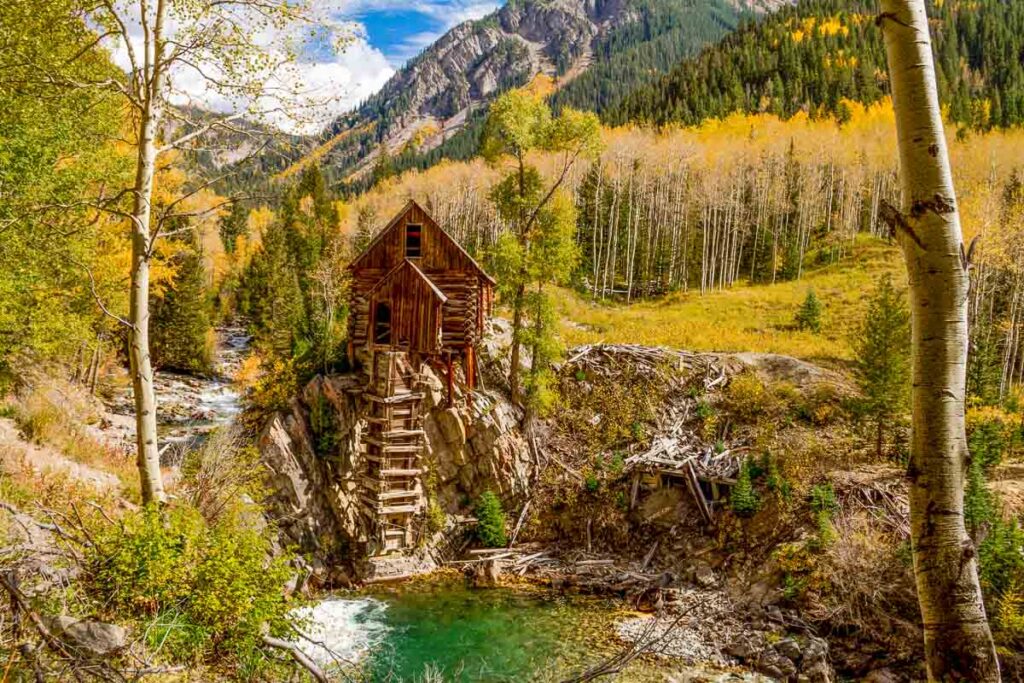 Fall colors surrounding abandoned historic landmark the Crystal Mill located on the Crystal River above the town of Marble Colorado on fall afternoon