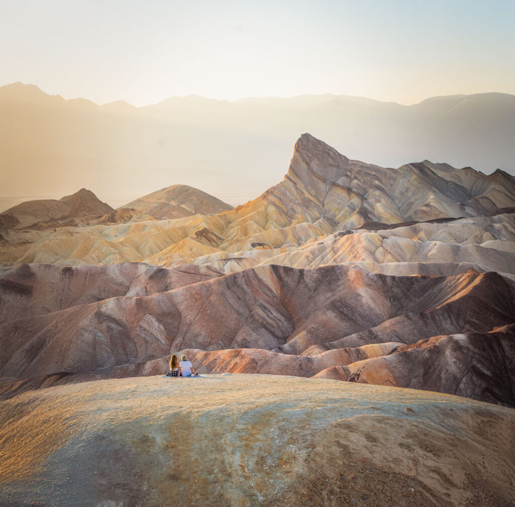 Zabriskie Point in Death Valley National Park at sunset with couple