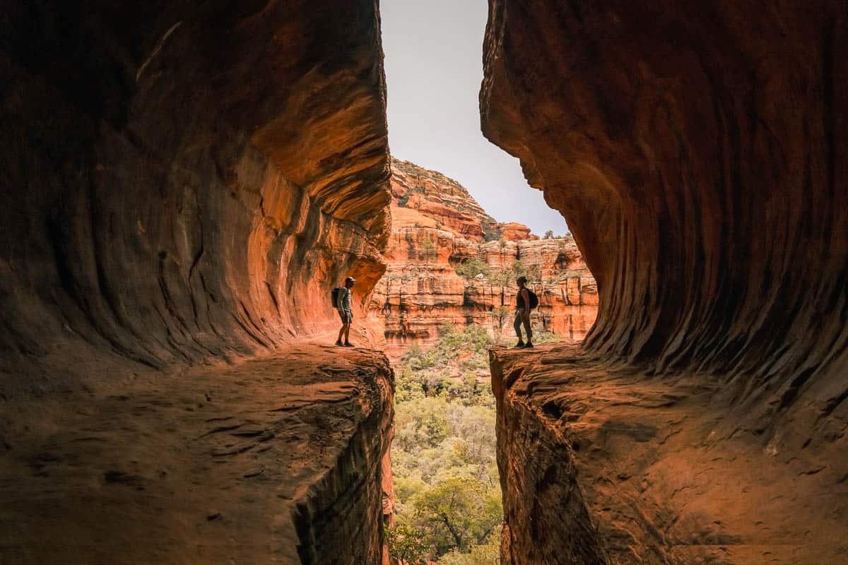 Young couple stands opposite each other in Subway Cave Boynton Canyon.