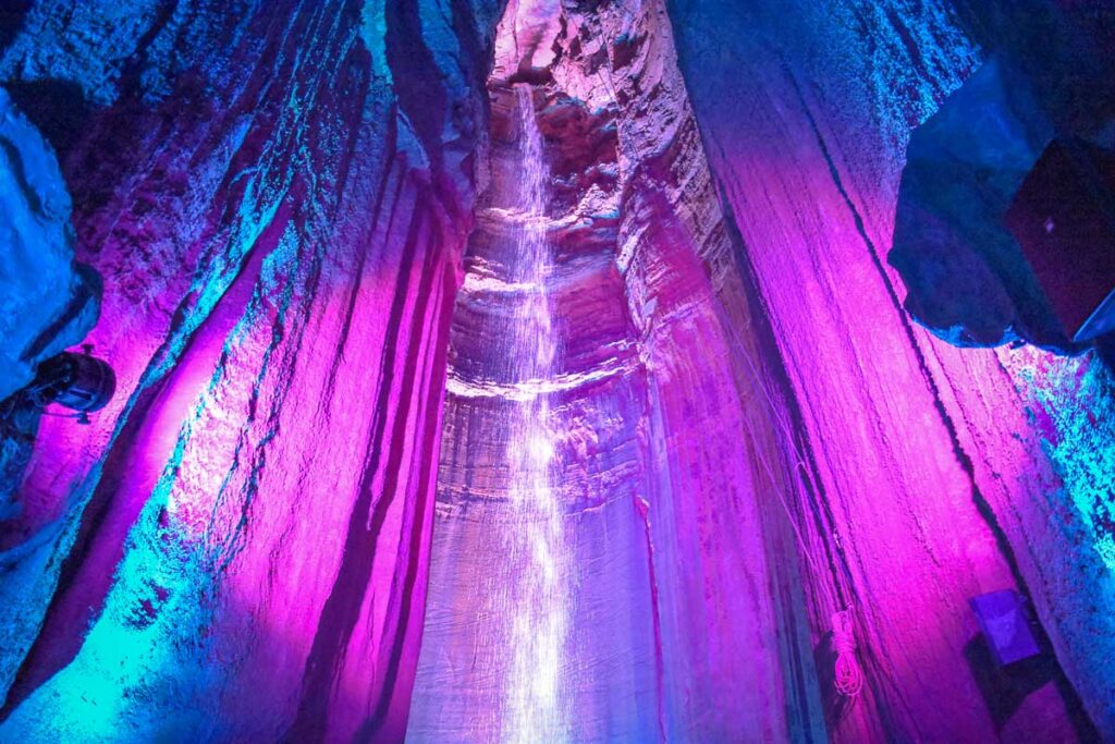 The colorful lights hitting the waterfall in Tennessee, Ruby Falls, one of the best Caves in the USA