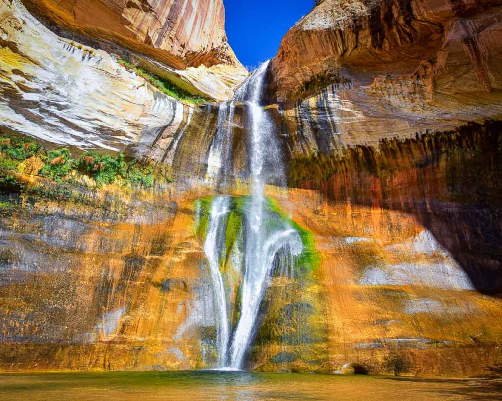 Water cascading down the colorful rocks of Lower Calf Creek Falls Escalante