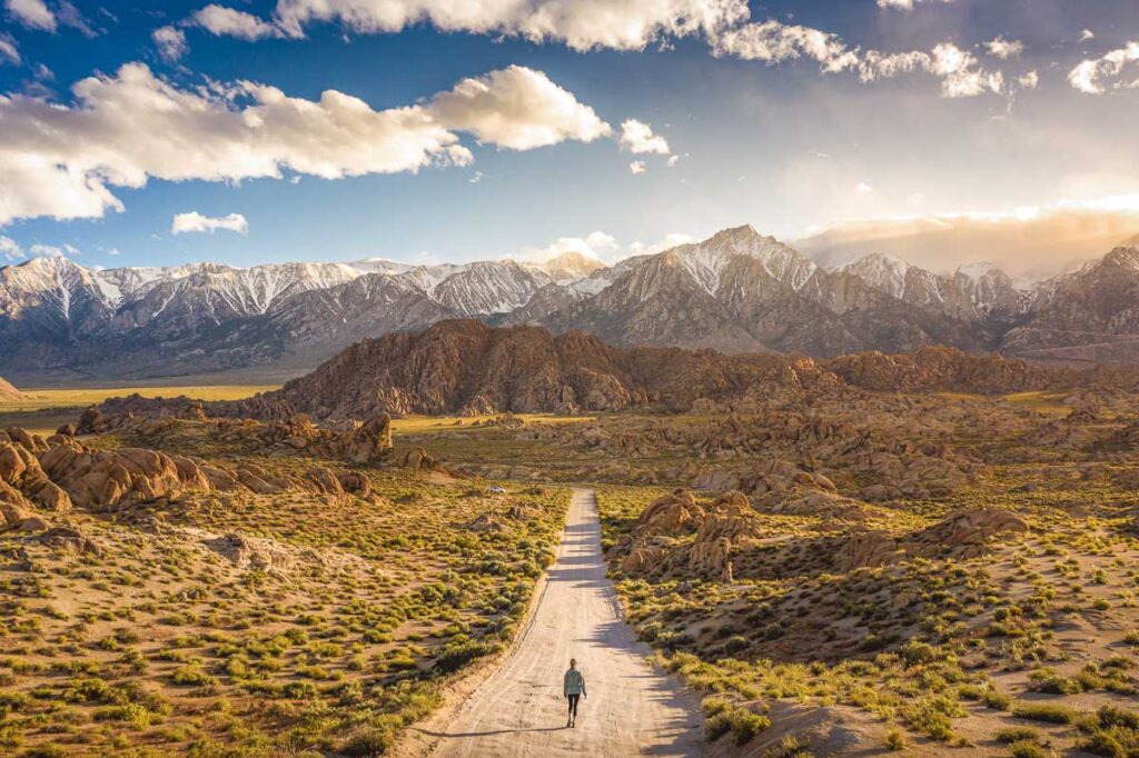 A lonely person walking on a pathway in Alabama hills in California with Mount Whitney in the background