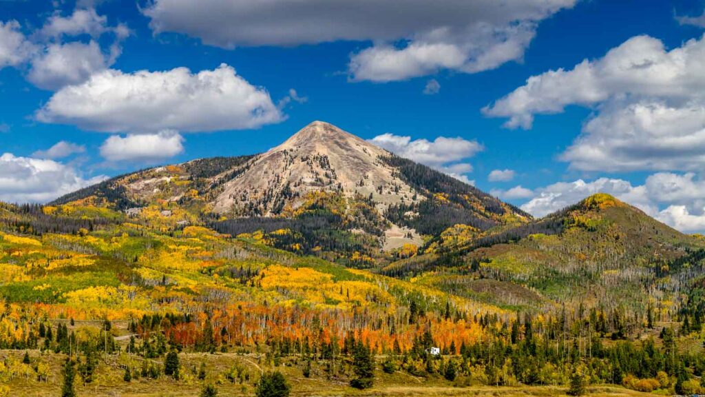 Hahn Peak near Steamboat Lake State Park with changing Aspen trees on mountain slopes on sunny autumn afternoon