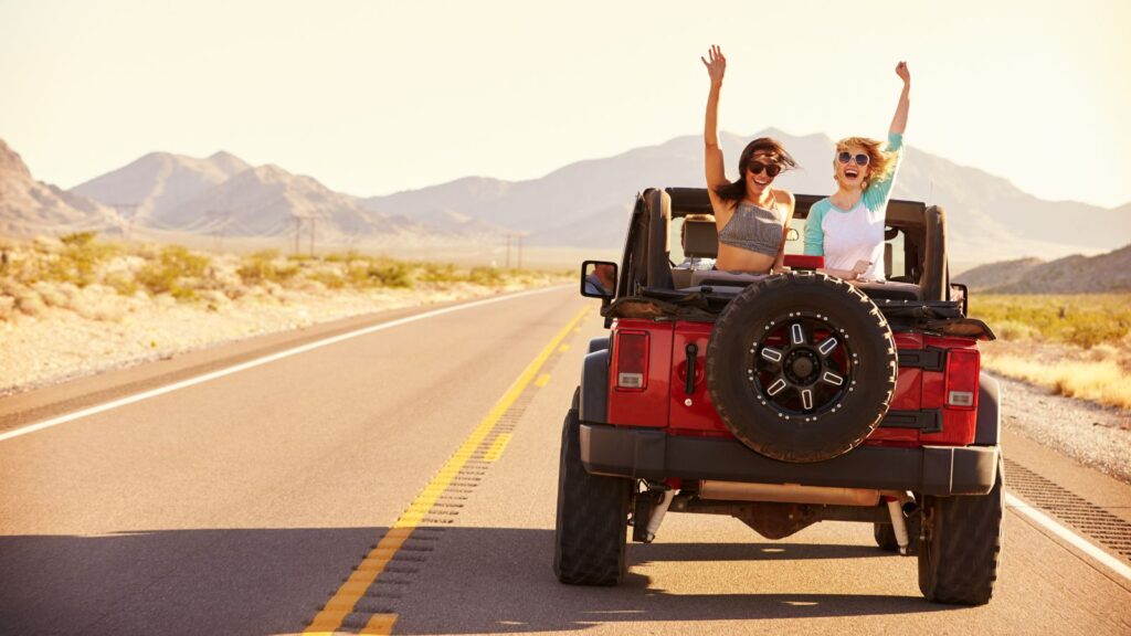 Desert Road Trip Two Girls driving down road