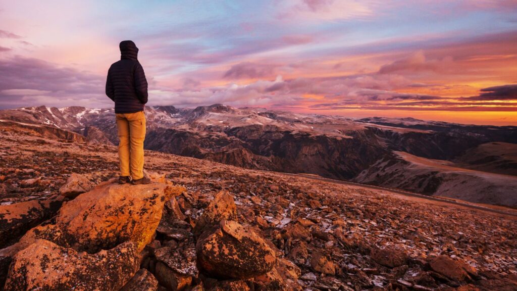 Person standing on Montana, Beartooth Pass Highway at sunset