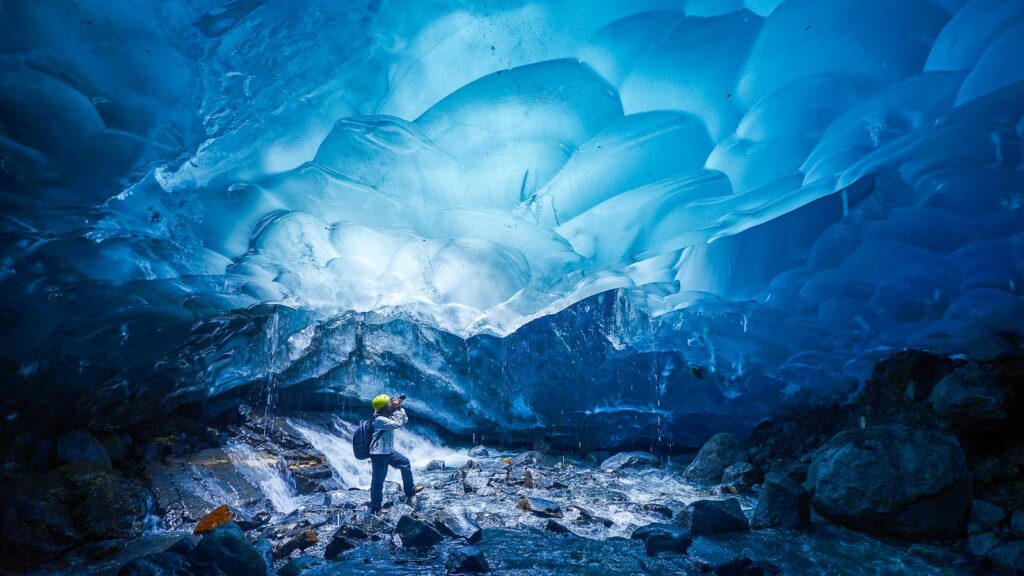 Alaska, man silhouette inside ice cave near Juneau