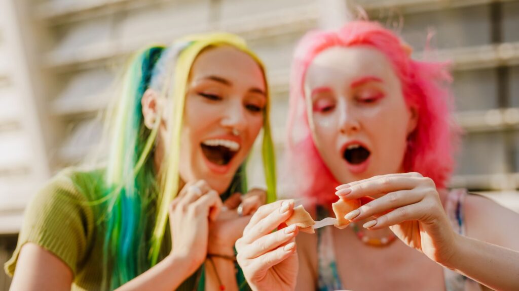 Young White Women Expressing Surprise While Eating Fortune Cookie