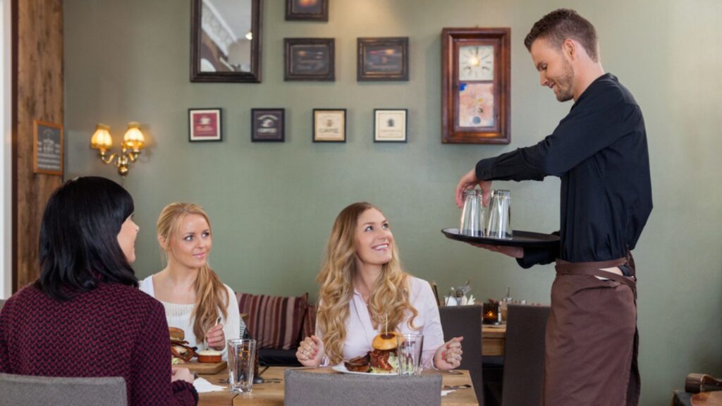 Waiter serving water to the customers