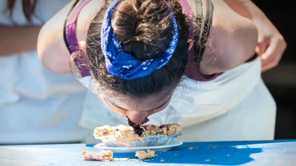 Young Girl Competing in Hands-Free Blueberry Pie-Eating Contest