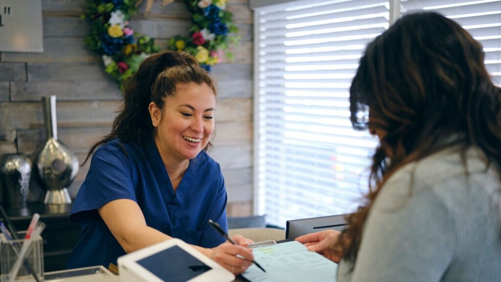 Two women signing into a clinic