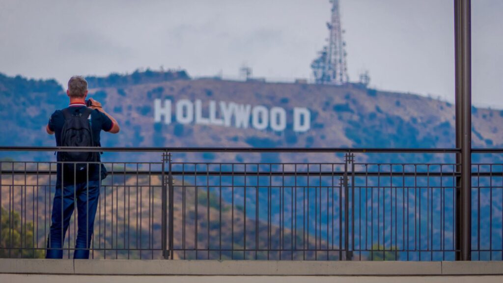 man taking pictures of the world famous landmark Hollywood Sign in LA