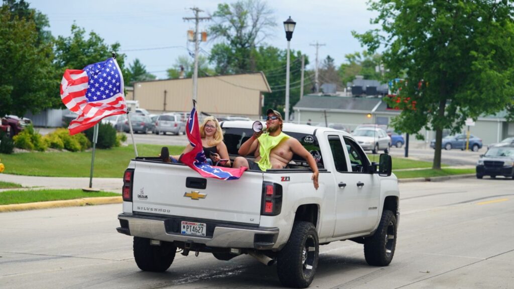 a man and a woman riding a pickup truck