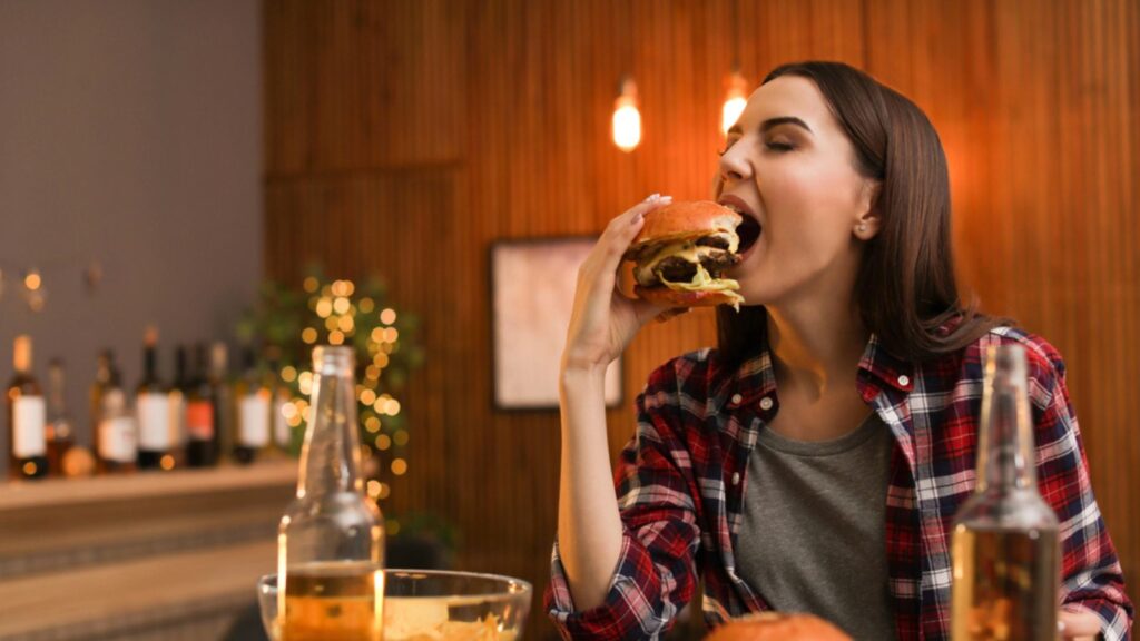 girl eating burger with lots of cheese