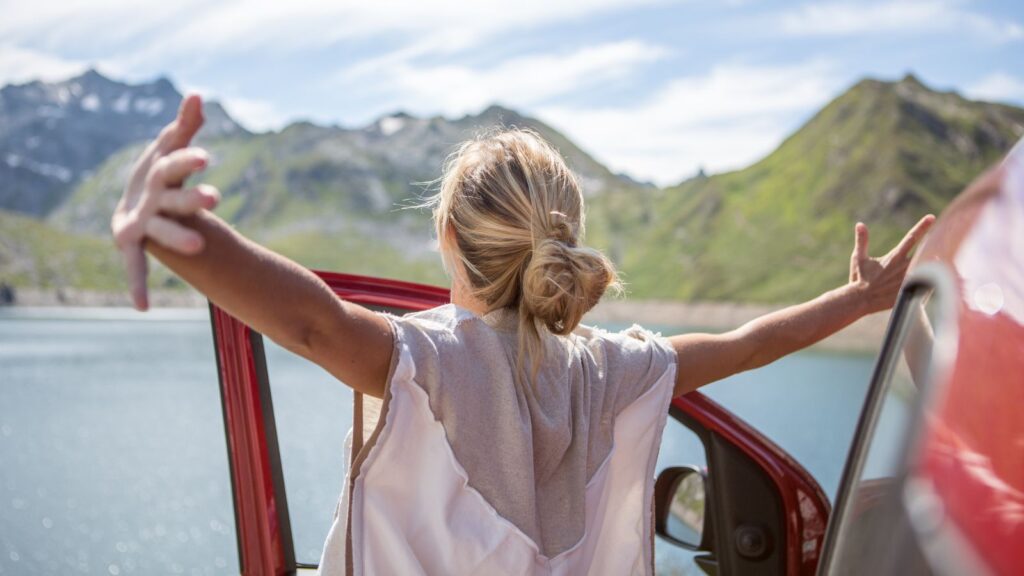 Women stretching out on roadtrip in front of lake