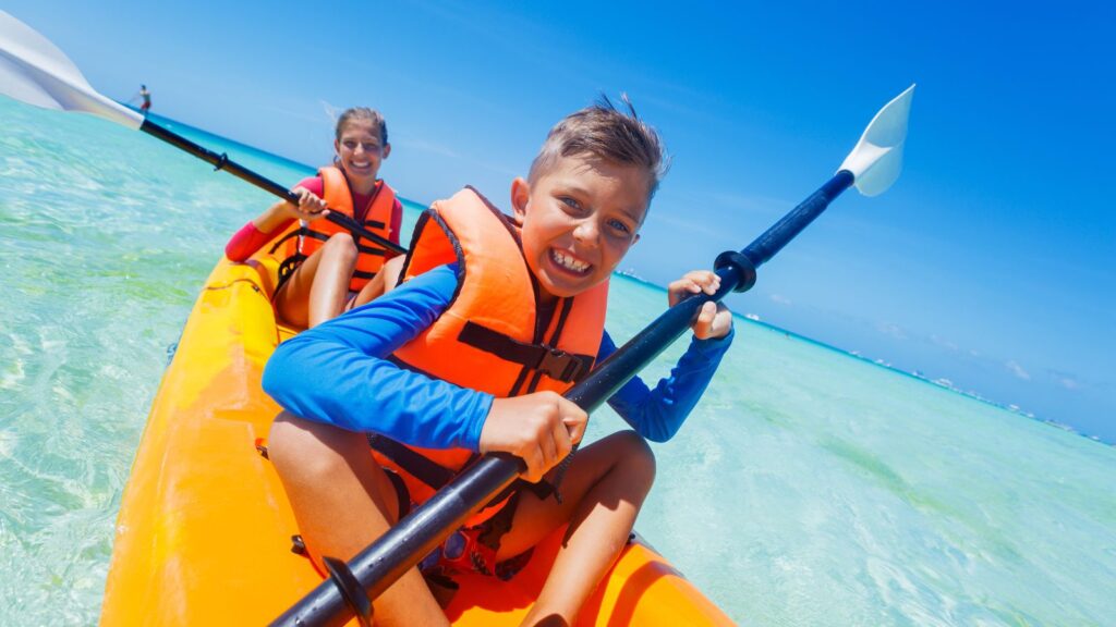 Kids paddling in kayak in Ocean