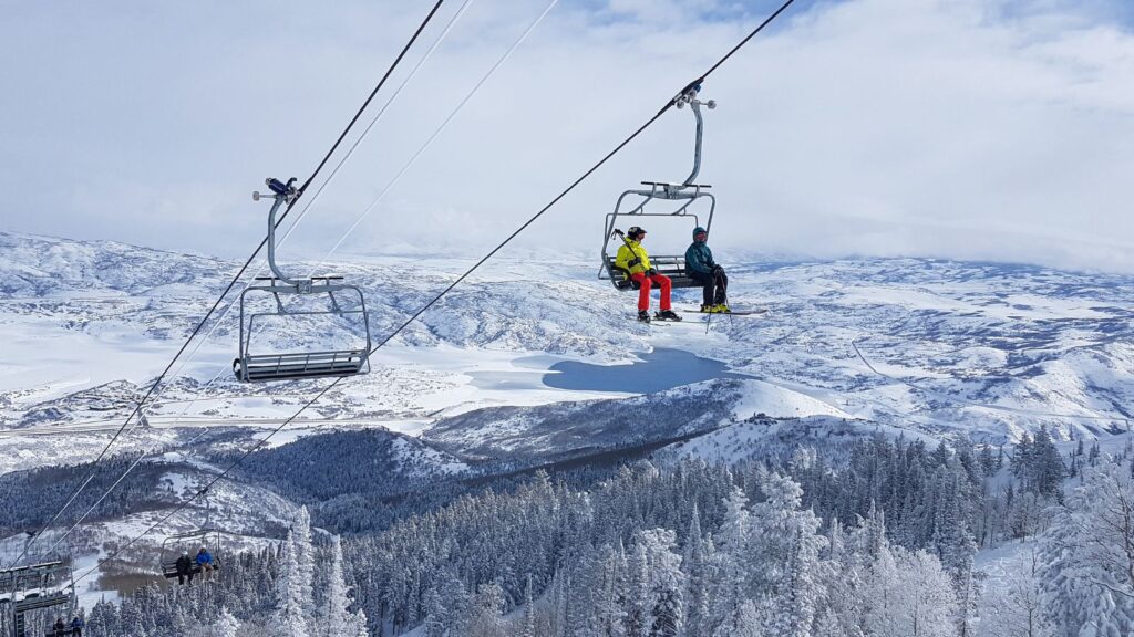 Utah, Two tourists skiing in Park City ride the chairlift to the top of the mountain