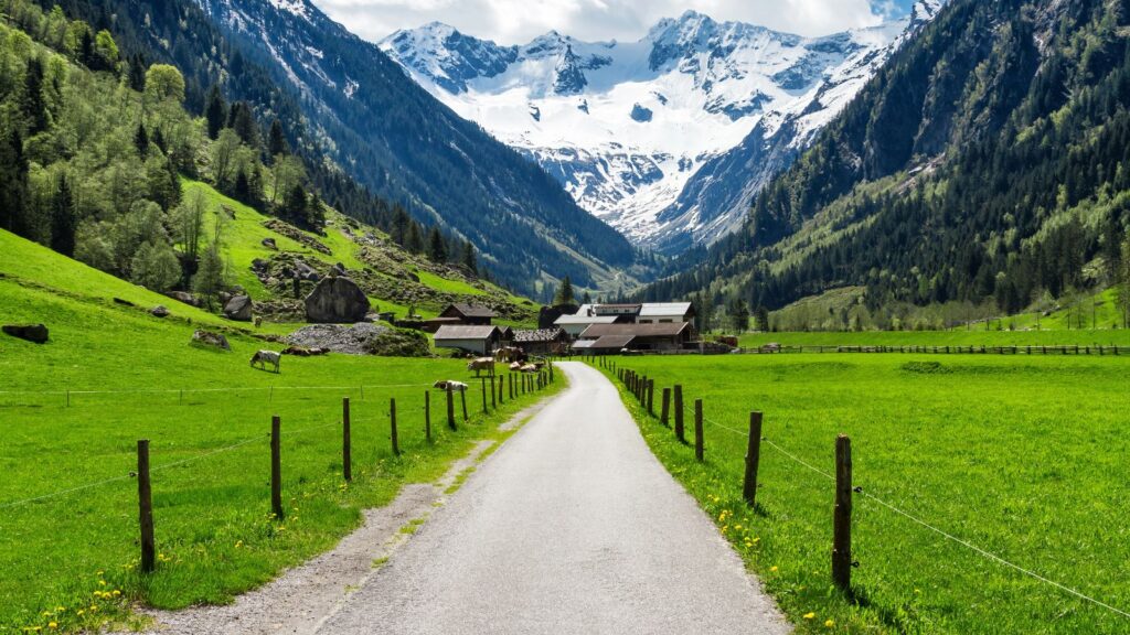 Austria, Austrian Alps during spring summer mountains landscape with alpine village and snowy peaks